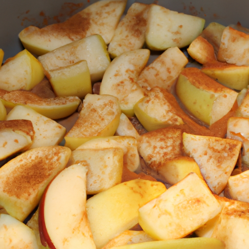 Sliced apples tossed in sugar and cinnamon, ready to be baked